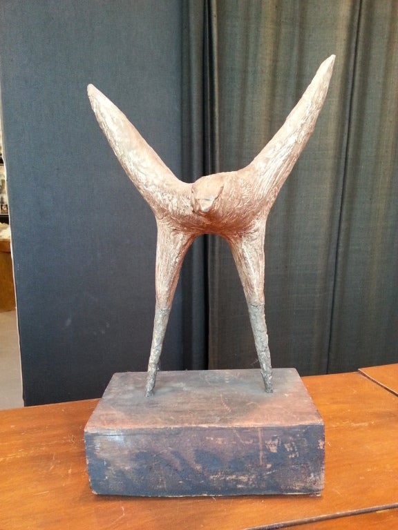 Midcentury sculpture of a bird of prey with expressive textured form in a concrete-like stoneware material poised atop cast bronze legs embedded in a rectangular wood platform base.

Artist unknown, probably midcentury American.
