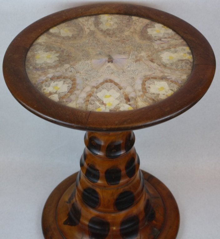 Gorgeous, unusual Brazilian pedestal table featuring a spectacular mosaic of butterfly-wing specimens under glass, above a tapering pedestal and circular platform base.

Labeled by maker 