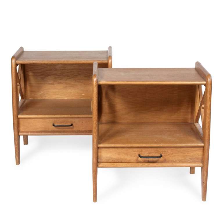 Two solid oak bedside tables by French designer, Jacques Adnet. The tables have croisillon sides with a lower drawer forming a shelf between gently tapering legs.