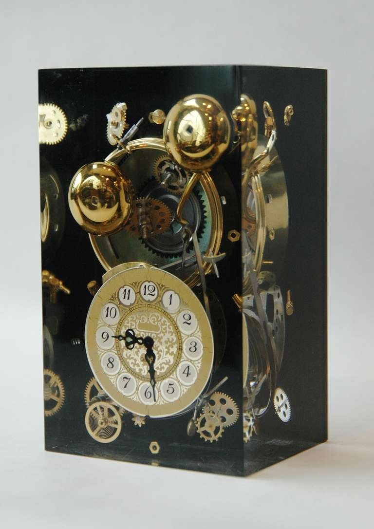 A Lucite clock sculpture displaying a clock face and pieces in the manner of French artist Arman.
Please note this is not a functioning clock.