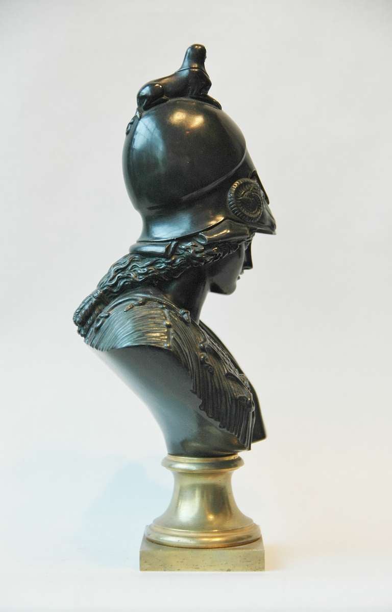 A bronze bust of Goddess Minerva/Athena in full uniform consisting of a helmet, chest plate and a draped cape. The helmet has two rams and a Egyptian sphinx located at the top. The bust sits on a gilded base.