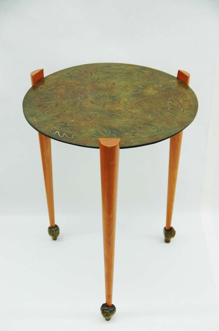 A bronze and oak table or pedestal by French Furniture designers, Elisabeth Garouste and Mattia Bonetti, titled Viviane. This table features three tapered legs with bronze details for feet. The top of the table is a thin piece of bronze with