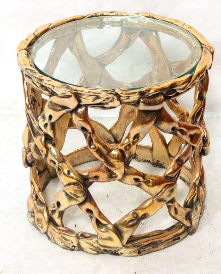 A  side table by Tony Duquette in a metalic copper tone finish with a round glass top insert named Pulled Taffy.