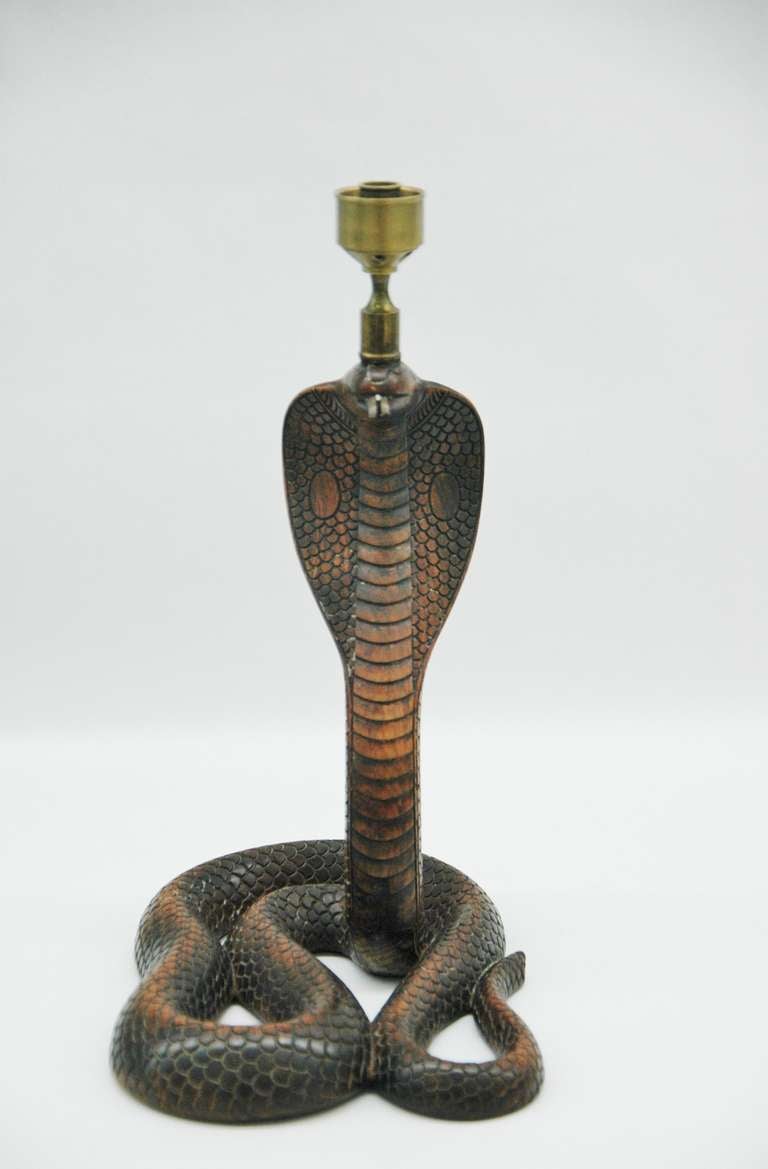 A unique pair of figural candlesticks depicting a standing cobra. The entire body is exquisitely carved to show scales with glass eyes with metal tongue.Attributed to the great English designer Anthony Redmille who is known for his unusual creations.
