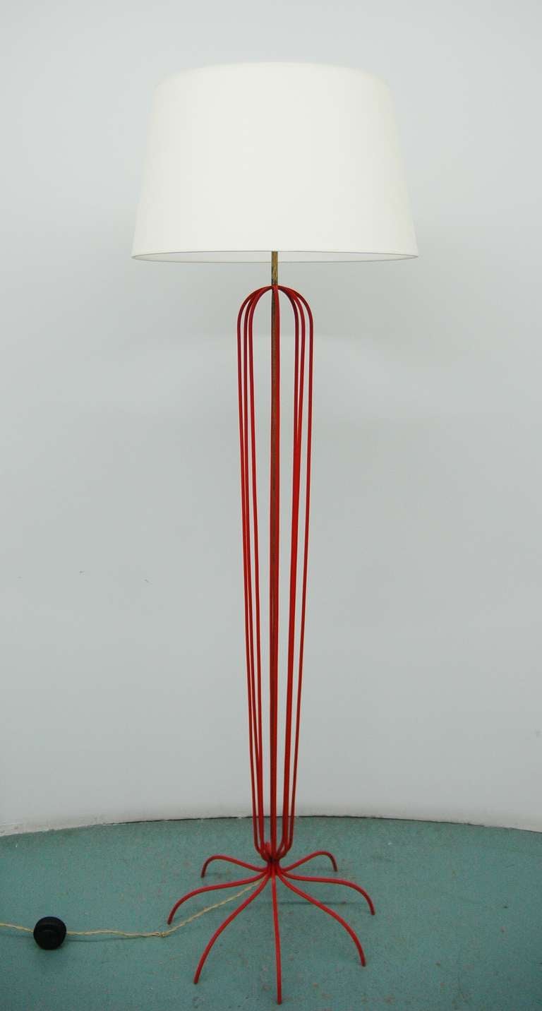 A whimsical red painted metal floor lamp reminiscent of the 