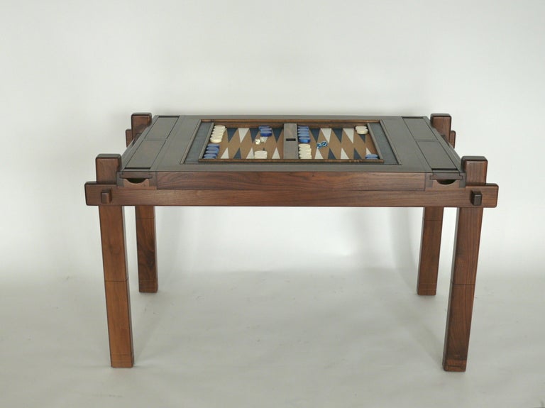 Handsome craftsman backgammon table made of solid walnut. Based off of a 1960s design. Game board is reversible with a beautiful brown leather on the opposite side.  Board and game pieces are vintage.  Fabulous piece!