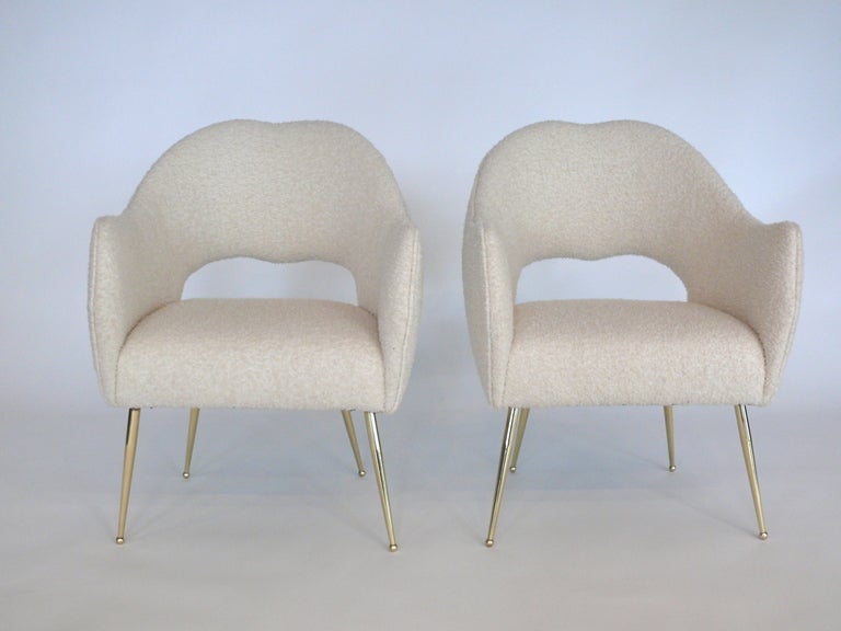 Fantastic pair of Italian chairs newly upholstered in creamy white wool boucle fabric and resting on angled polished brass legs. Incredible lines with an open back. Absolutely stunning. Matching settee also available! 