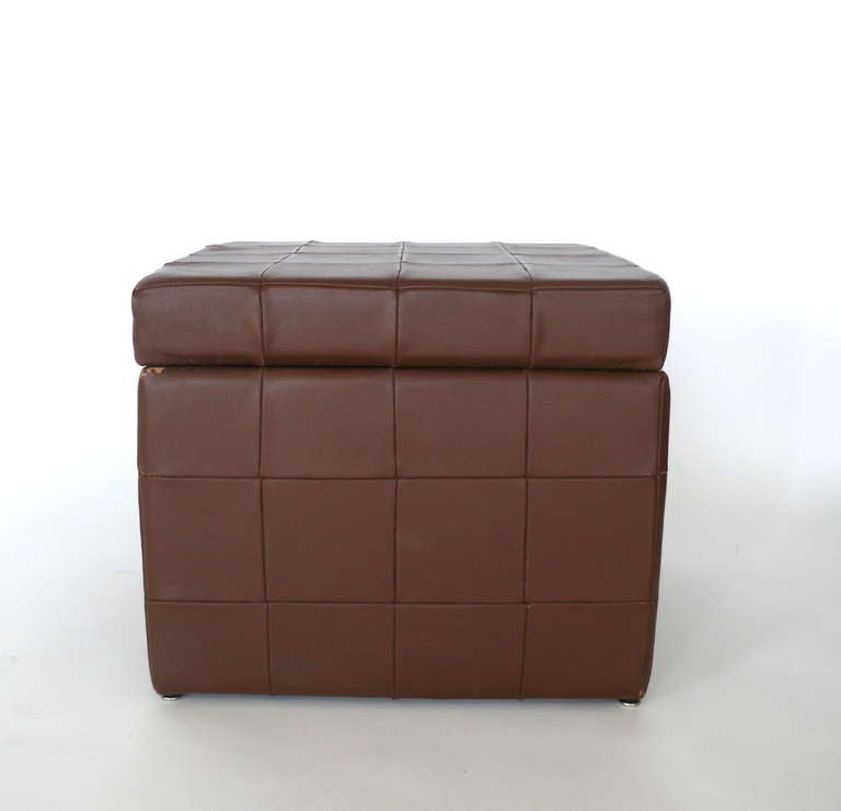 All original patchwork leather ottoman. Original brown leather in great condition with light signs of wear and patina. Ottoman opens to reveal a deep storage bin.