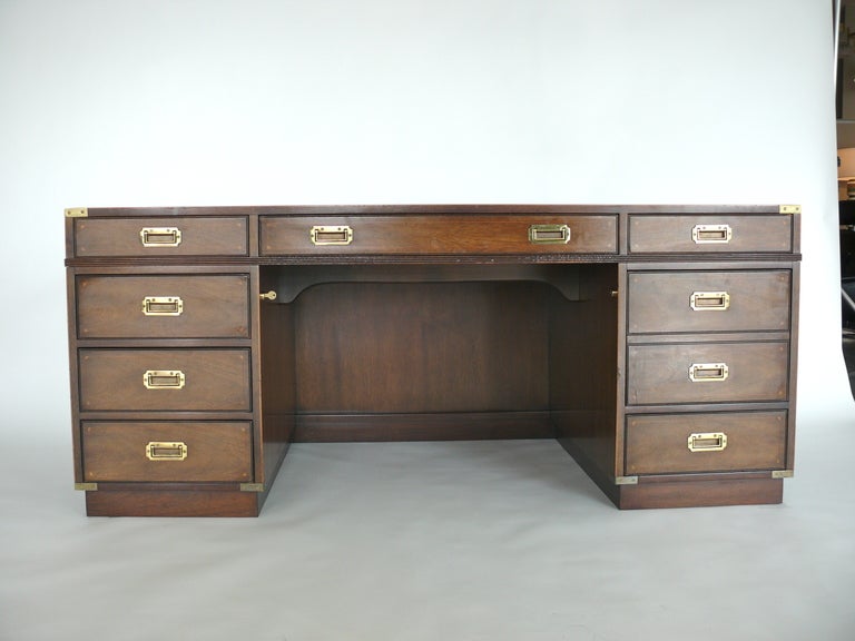 Stunning rosewood and leather campaign desk by Kittinger. Beautiful leather inlay on top surface with gold detail.  Incredible brass campaign hardware on all four sides of the desk.  Great storage which include 8 Drawers.  Drawers on front side do