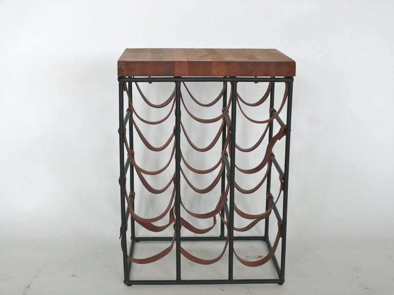 Classic Arthur Umanoff wine rack. Made of black iron, original leather and butcher block. Leather straps have patina with brass rivets.  Holds 12 wine bottles!