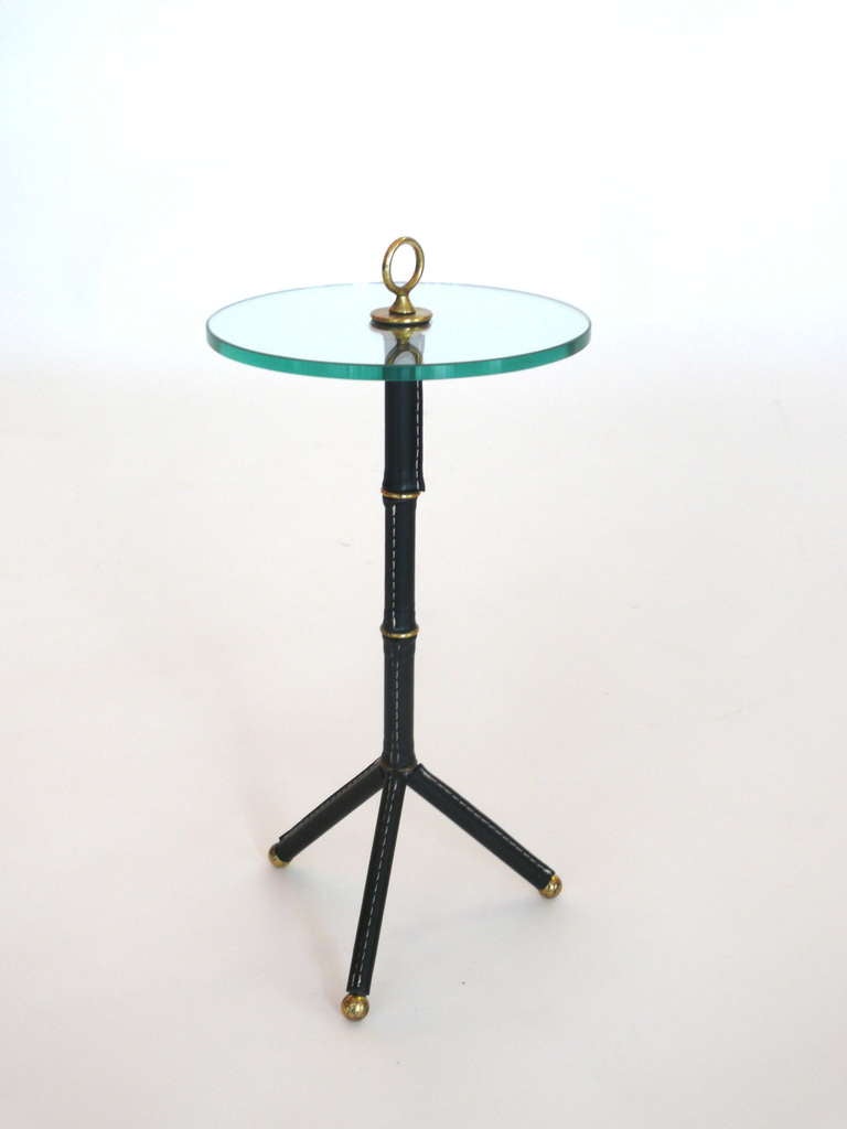 Petite scaled cocktail table with signature Jacques Adnet bamboo leather and white contrast stitching. Great Brass ball feet and detail. New glass top.