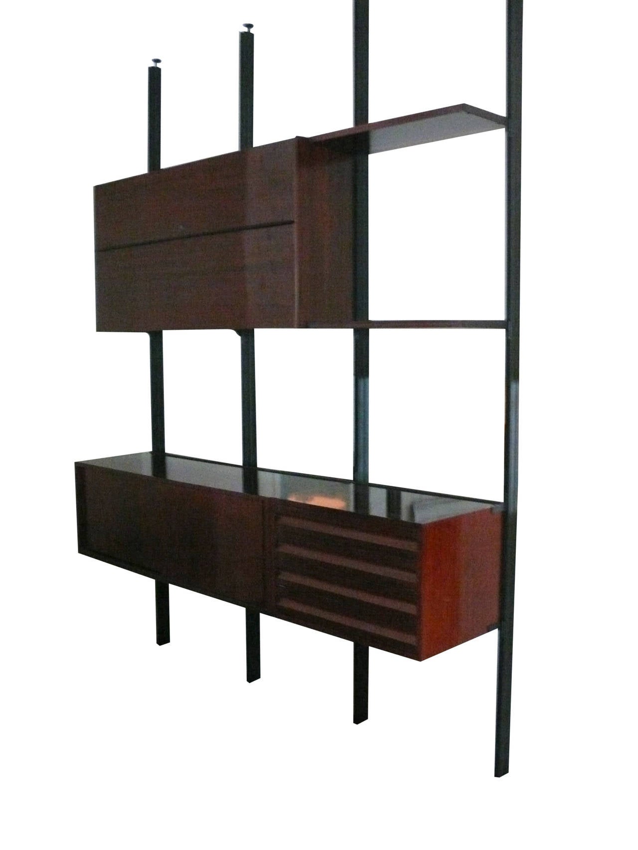 Elegant wall unit or bookcase by Borsani for Techno, Milano. Rosewood has been newly refinished with a hand rubbed polish. The case features four vertical steel columns which hold the interchangeable wood pieces. The upper unit consists of a cabinet