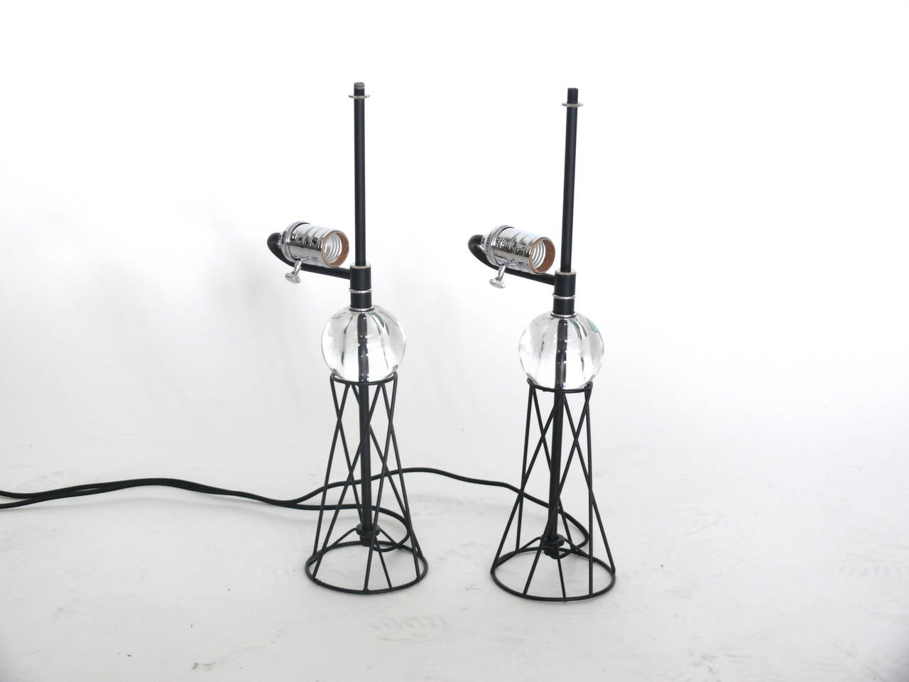 Excellent iron and glass table lamps by Robert Abbey. Glass orb sits atop a circular iron base with crisscross design. Excellent lines. Newly rewired.