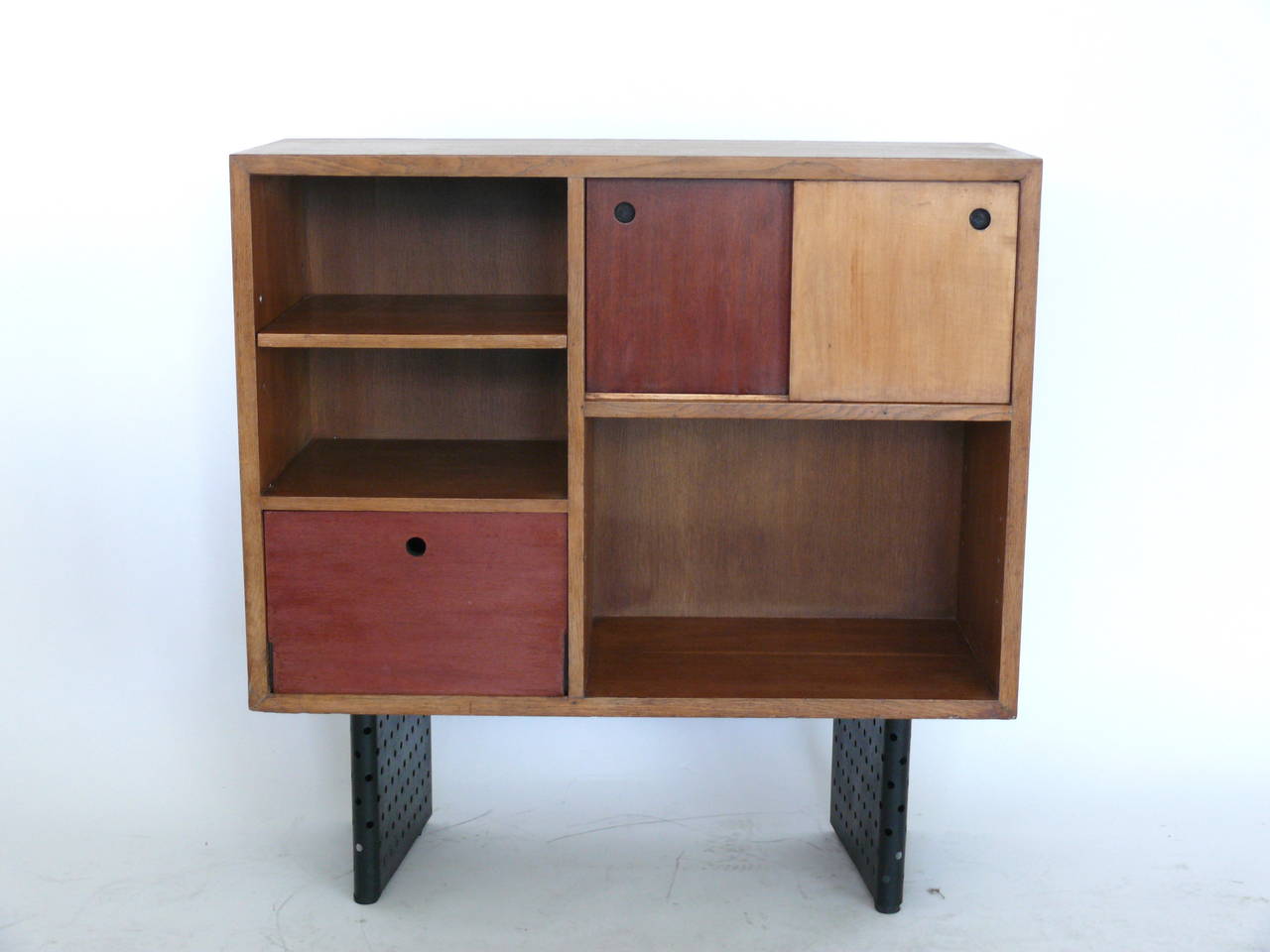 Gorgeous cabinet or bookcase designed by Escande, a student of Prouve. The cabinets are made of oak and rest on perforated iron legs. Designed for the Anthony building in Strasbourg, France. Two other versions also available.