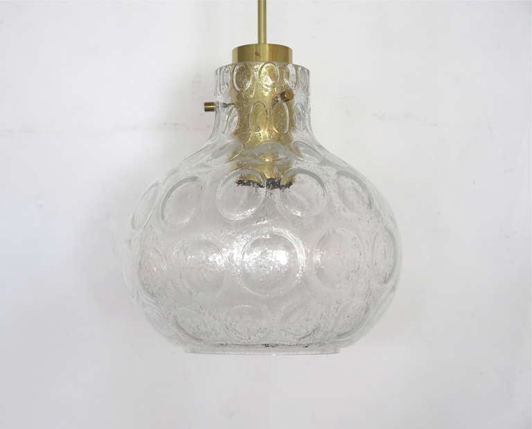 Petite Austrian glass globe pendant with bulbous clear glass with textured circles in surface. Glass suspended and floats from 4 brass pegs and fixture. Newly re-wired. Extremely similar second pendant also available.