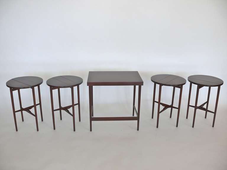 Extremely handsome walnut end table with four rounded drop-leaf nesting tables by Bertha Schaeffer for Singer & Sons. Newly refinished in a French polish. Original label on underside. Excellent and versatile pieces providing expandable