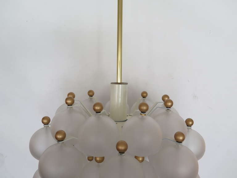 Beautiful chandelier with vertical hanging frosted glass globes and brass ball spacers attributed to Seguso. Interesting design with great scale! Newly re-wired.