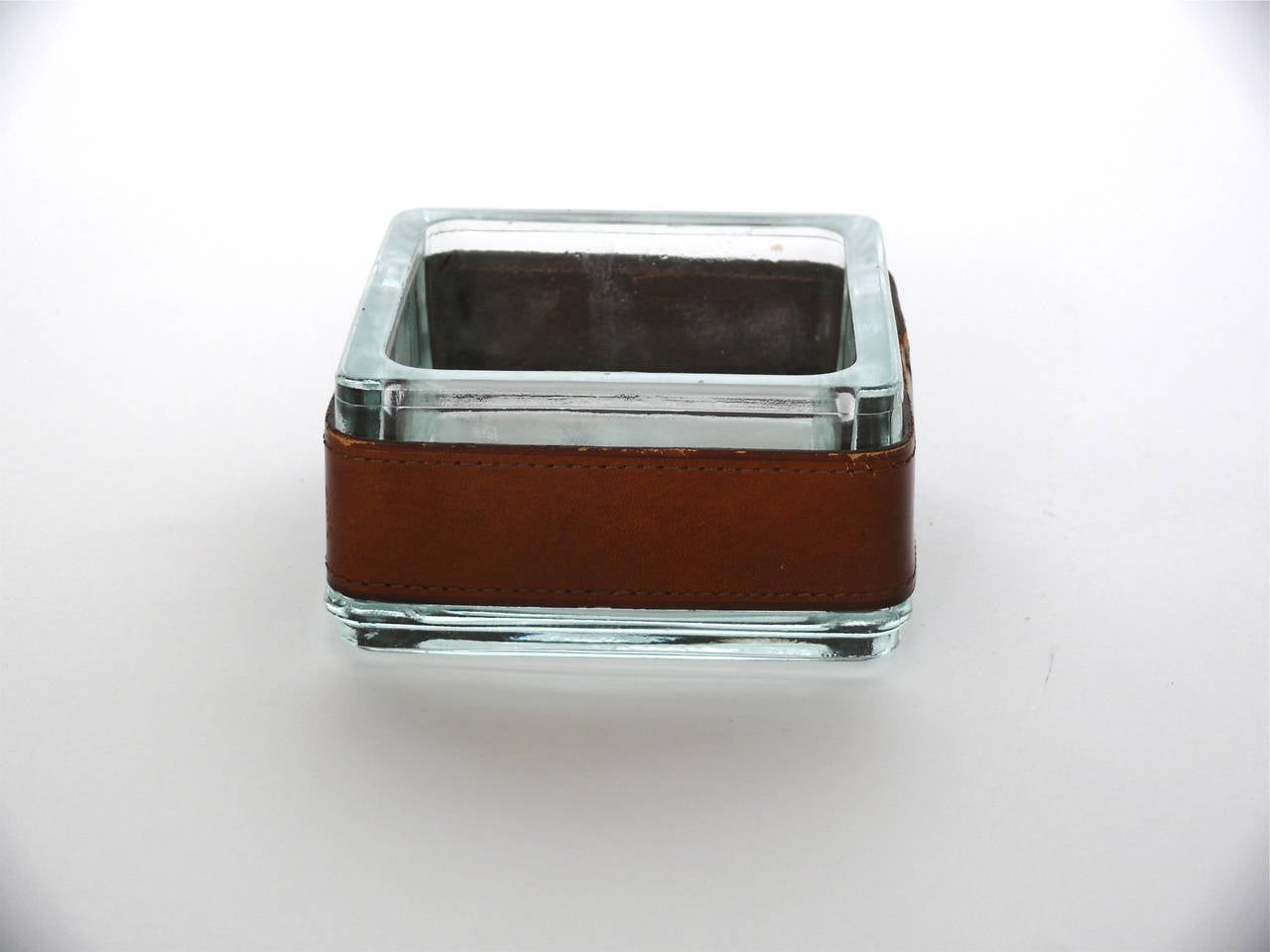 Handsome leather and glass catch all or ashtray. Square glass with distressed saddle leather band. Good vintage condition.