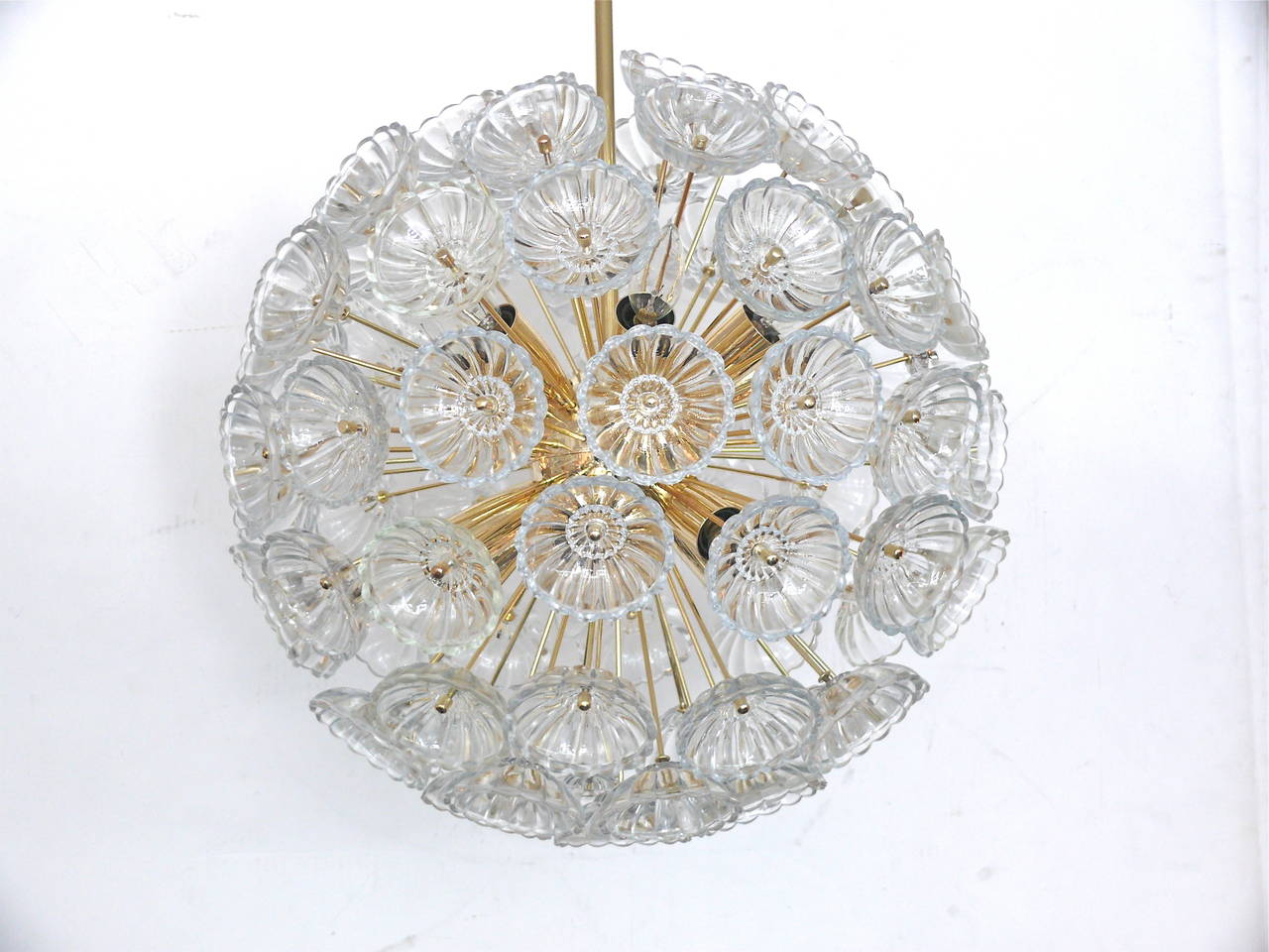 Large-scale brass and glass Sputnik chandelier. Multiple brass arms extend from a brass center ball. Two smaller matching chandeliers also available. Illuminates beautifully!