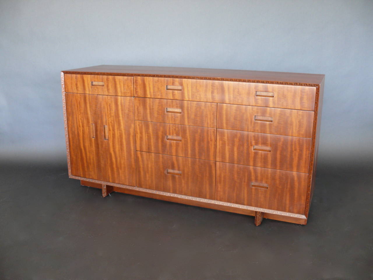 Beautiful dresser by Frank Lloyd Wright manufactured by Heritage Henredon. Distinct carvings from the Taliesin Line which was named after Frank Lloyd Wright's home in Spring Green, Wisconsin. Signed by FLW and newly refinished.