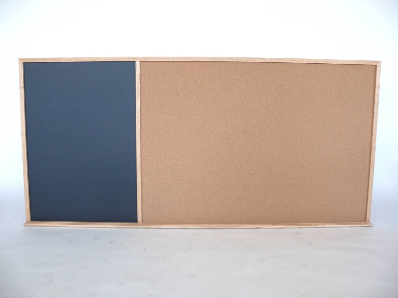 Whimsical organizational board with cork board, black magnetic chalkboard and oak frame. Bottom tray runs the length of the board. Magnetic chalkboard section is 28