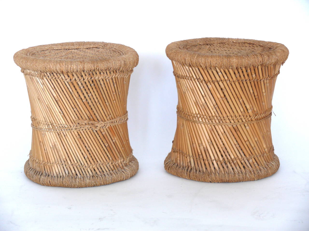 Fantastic pair of wicker and rattan end tables. Angled strands of wicker, with woven rattan and hemp at the top and bottom. Can also be used as stools. Very functional. Excellent vintage condition.