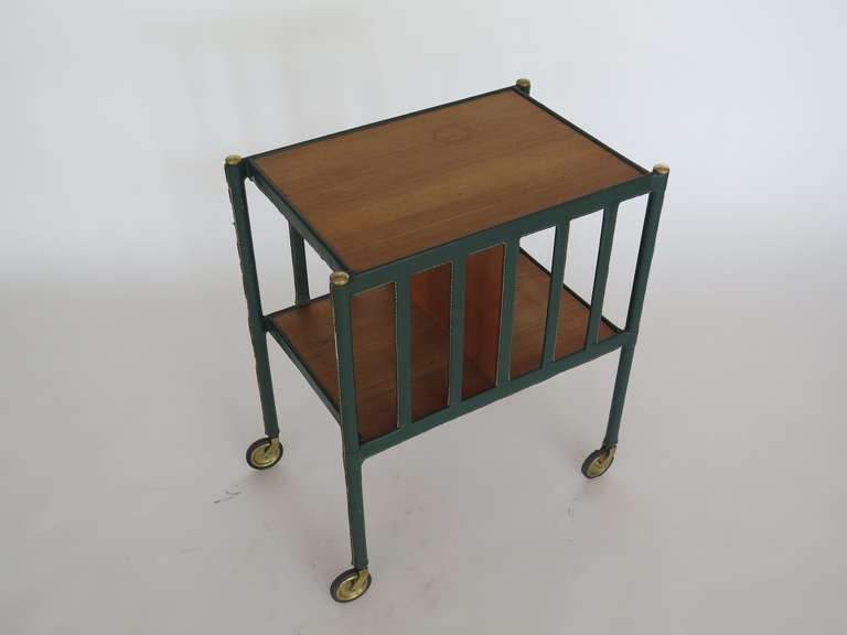Stunning Jacques Adnet bar cart wrapped in rich hunter green leather with signature white contrast stitching through out. Wood has great wear and patina throughout. Original brass casters.