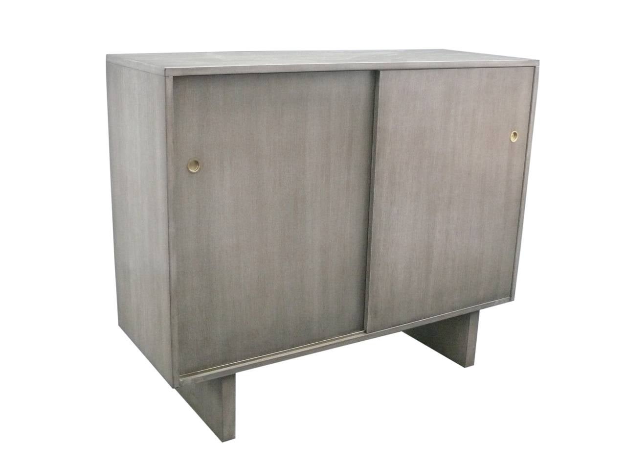 Unique sliding door cabinets by Widdicomb. Each cabinet has multiple drawers in various sizes. Two pull-out brass bars for ties or belts. Widdicomb label on inner drawer. Both cabinets have been newly refinished in a medium gray. Great for a