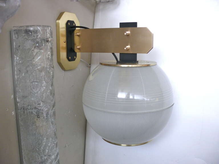 Pair of globe sconces with ribbed and textured glass by Azucena. Large in scale with beautiful brass hardware. Newly rewired. Multiple pairs available.