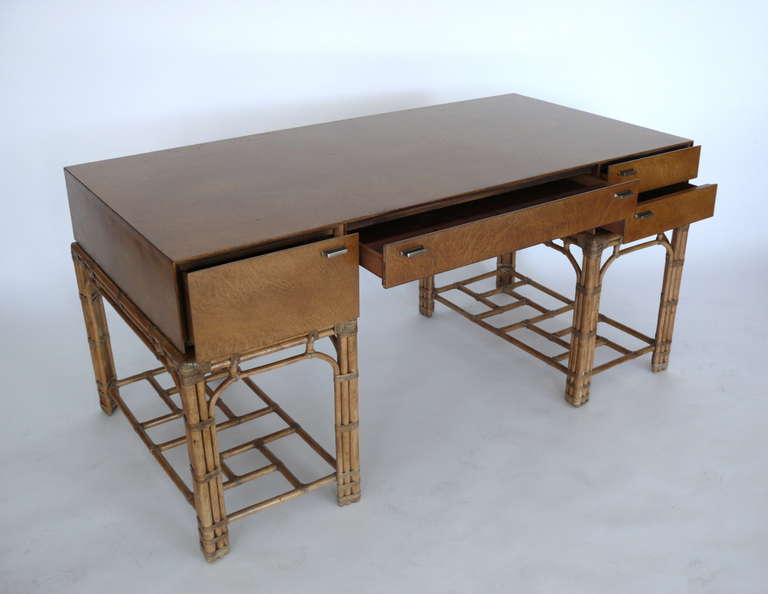 Wonderful burled olivewood campaign desk by Gene E. York for Henredon. Four drawers with nickel hardware provide ample storage. Beautiful bamboo frame with wrapped leather corners and detailing. Great workspace!