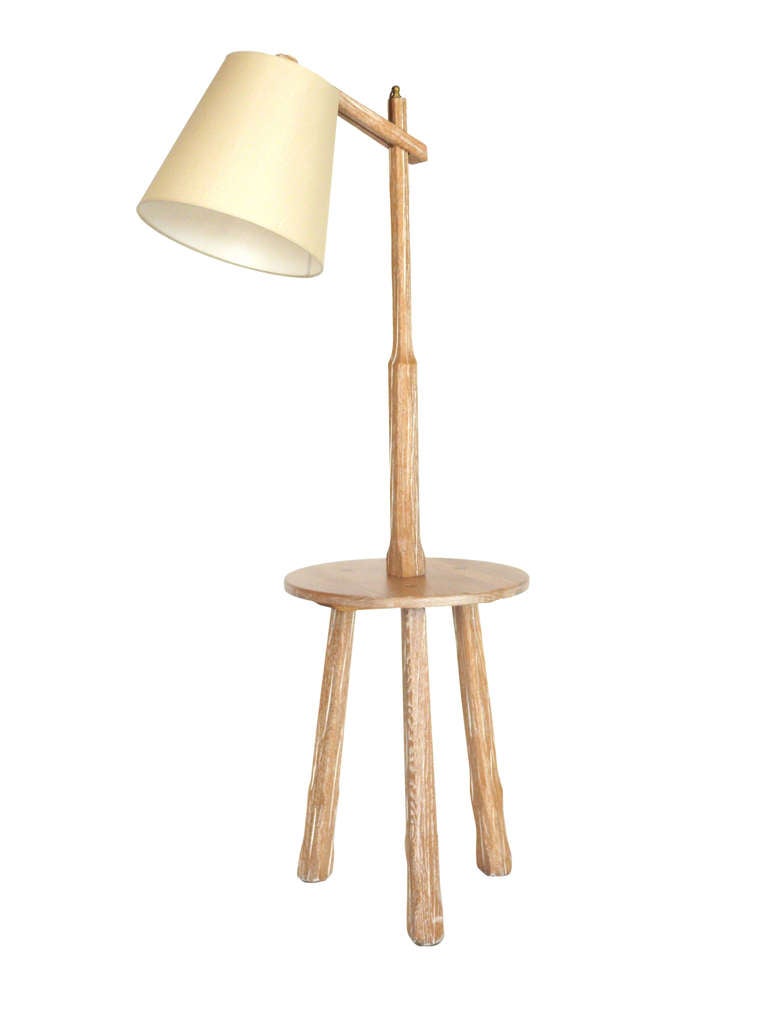 Great floor lamp by Brandt Ranch in a beautiful light cerused oak finish. Lamp features an angular arm that extends outward with new silk shade. Functional circular table that rests on a three legged base. Perfect in between two chairs! Newly