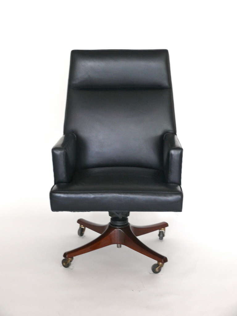 Handsome executive desk chair by Dunbar. Original leather has been recently color washed to a midnight blue. Four star wood base with original casters. Nice large scale and very comfortable!  Label on underside.