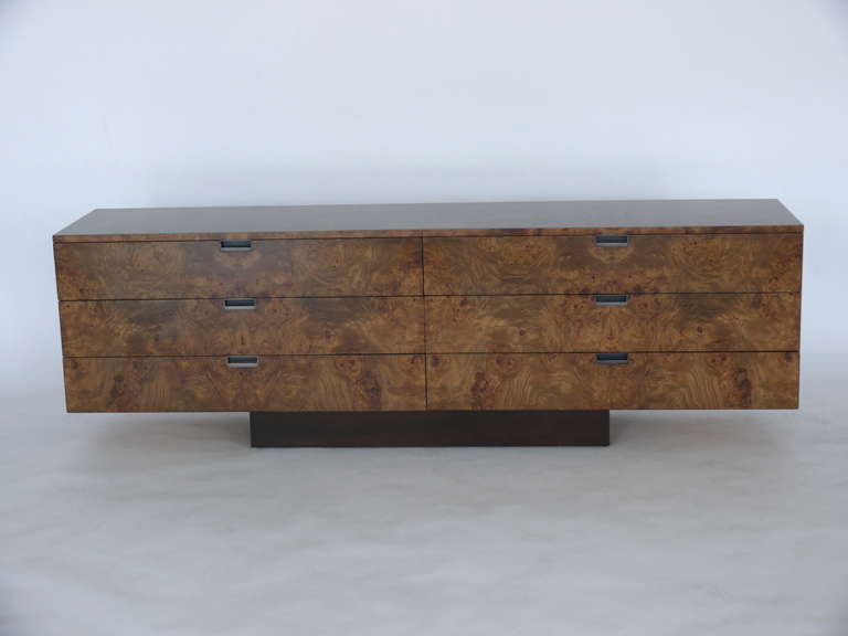 Handsome olivewood credenza by Roger Sprunger for Dunbar. Six pull out drawers provide ample storage. Floats on dark brown walnut base. Newly refinished. Great size and function!