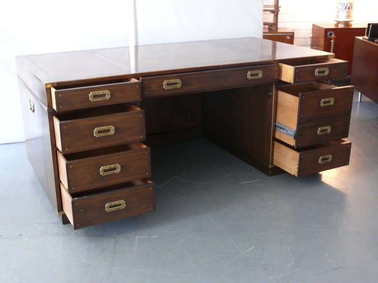 Fantastic rosewood campaign desk by Kittinger. Brass hardware on all four sides and corners of the desk. Great storage which include 8 drawers.  Large in scale and a beautiful statement piece.