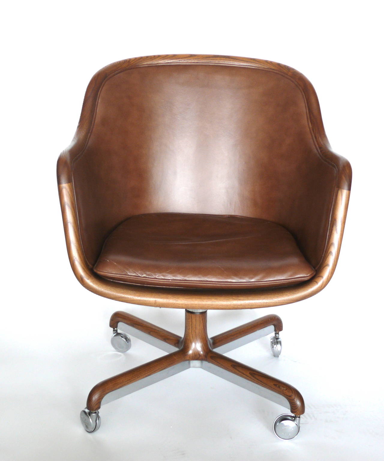 Handsome oak and leather office chair by Ward Bennett. Bucket seat with bottom cushion. Chrome base with oak trim adds a unique detail. Original leather has beautiful patina. Chair is in excellent vintage condition with original casters. Priced