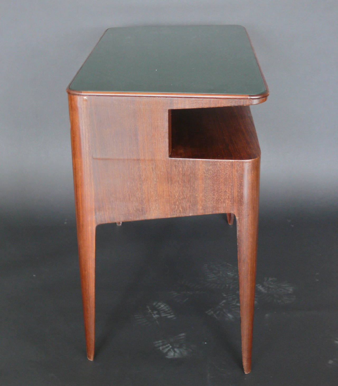 Elegant vanity by Gio Ponti. Rosewood vanity with green inlaid stamped glass top by Fontana Arte. (Stamped Fontana on underside of glass) Tapered legs and open shelf. Very rare piece. Excellent vintage condition. Vanity is cataloged in the Gio Ponti