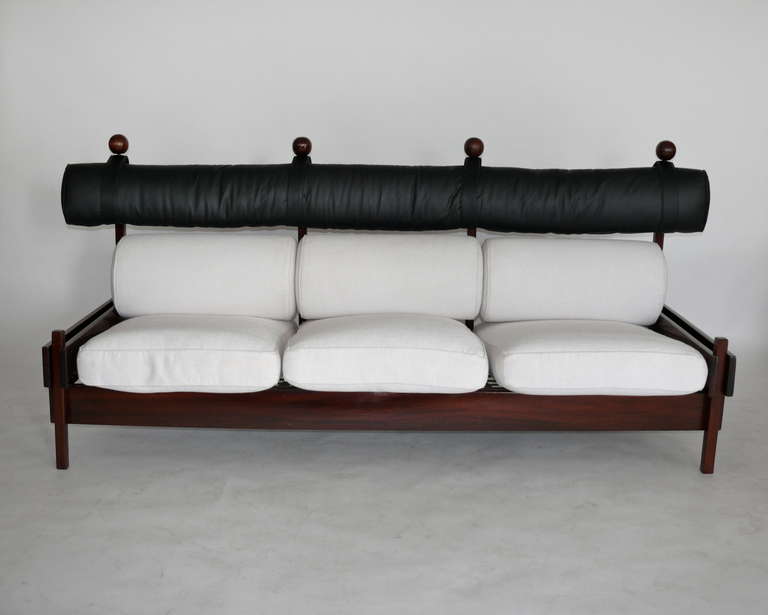 Incredible sofa by Sergio Rodriguez from the "Tonico" series for Oca. In 1955, Rodrigues opened Oca, which he referred to as "the laboratory for Brazilian furniture and handicrafts". Rich jacaranda wood accompanied by black