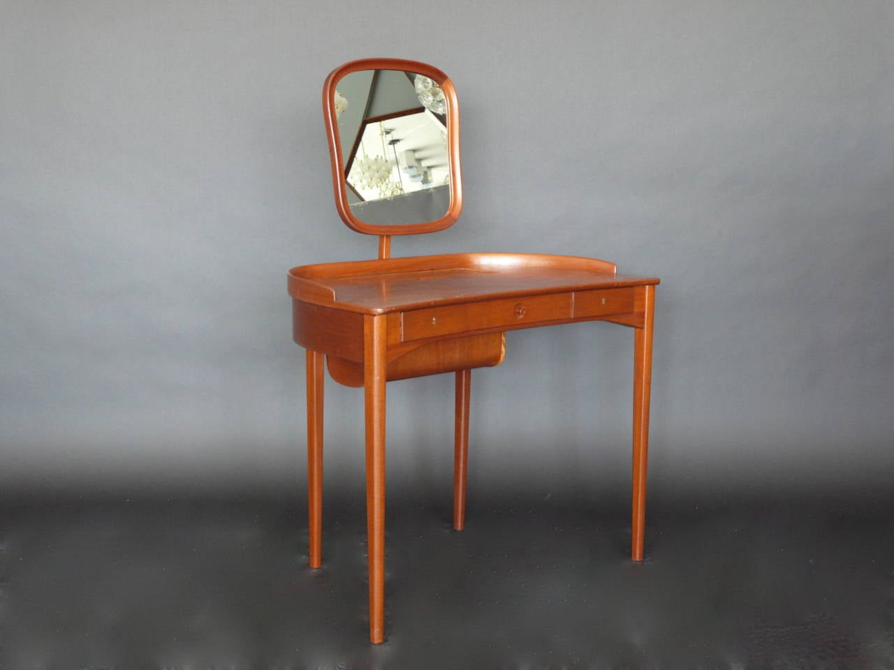 Handsome German vanity made of mahogany. Adjustable mirror and hidden drawer. Three additional drawers complete with original locks and key. Fantastic scale and clean design. Original vintage condition.
