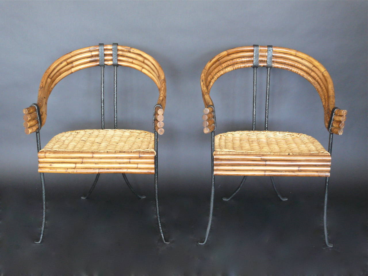 Whimsical set of bamboo and iron chairs. Iron frame with continuous bamboo on backrest and arms. Rattan seat in excellent condition. Priced as a pair.