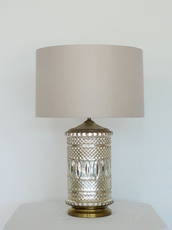 Stunning pair of large cylindrical mercury glass lamps with silver metalic glass and brass base. New grey silk shades and professionally rewired. Beautiful and intricate detail in glass and truly one of a kind!