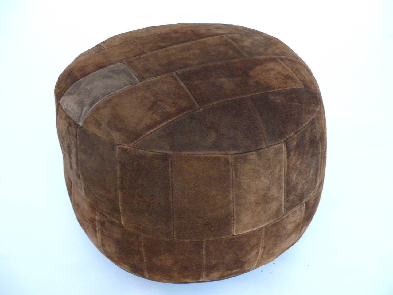 Great patchwork ottoman by De Sede. Original suede in excellent vintage condition. Perfect size. Matching pair of brown suede patchwork ottomans also available.
