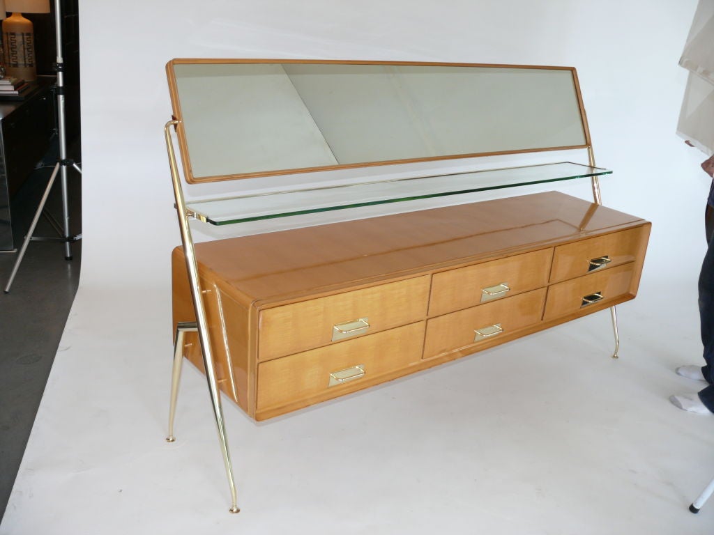 Rare Italian dresser by Silvio Cavatorta with 6 drawers, pivoting mirror and glass shelf. Beautiful original light wood finish.  Polished Brass hardware has been newly plated and is not sealed so will patina beautifully.<br />
<br />
2 matching