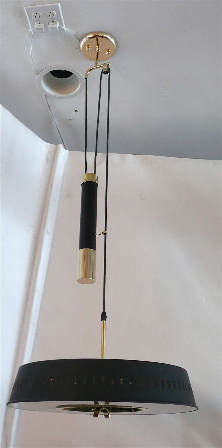 Beautiful ceiling light with black dome perforated shade and solid brass and black counterbalance for adjustment of shade height. Glass diffuser with brass arch to pull light up and down. Stunning design with great function. Newly re-wired. Light