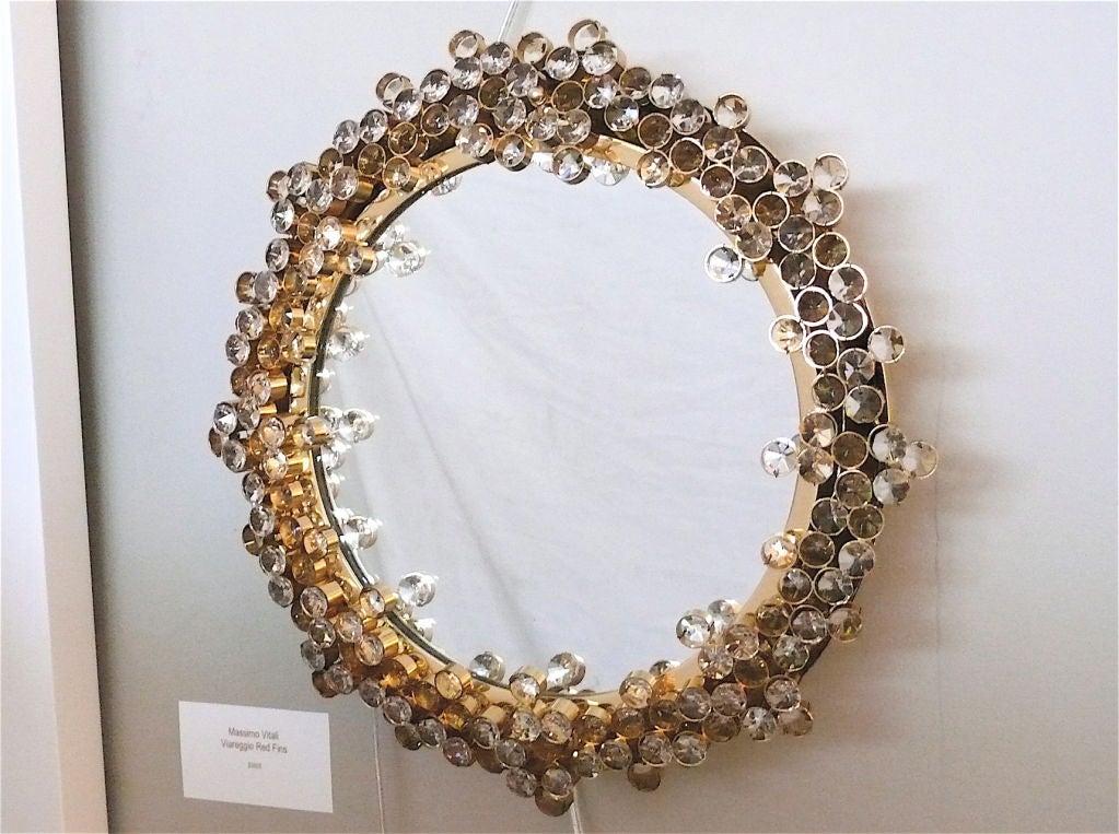 Magnificent Austrian backlit mirror by Palwa, the large individual jewel-like crystals intricately placed in a subtle brass circle encompassing the mirror. The illumination through the crystals creates a stunningly beautiful glow. 

Newly re-wired.