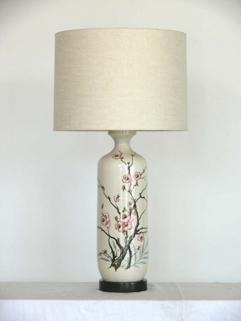 Beautiful pair of large ceramic lamps by Marbro. Stunning and intricate hand painted cherry blossom design on face. Cylindrical lamp made off white ceramic with crackled finish. New dark wood bases and new linen shades. Lamps have been newly