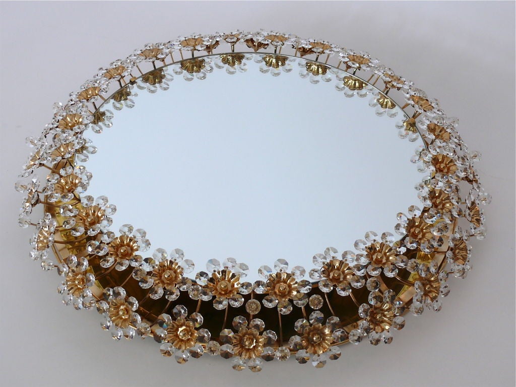 Stunning Italian backlit mirror with two rows of cut crystal balls and flowers with brass centers attached to curved outstretched brass arms. Light illuminates through flowers to create a beautiful glow. Professionally re-wired.