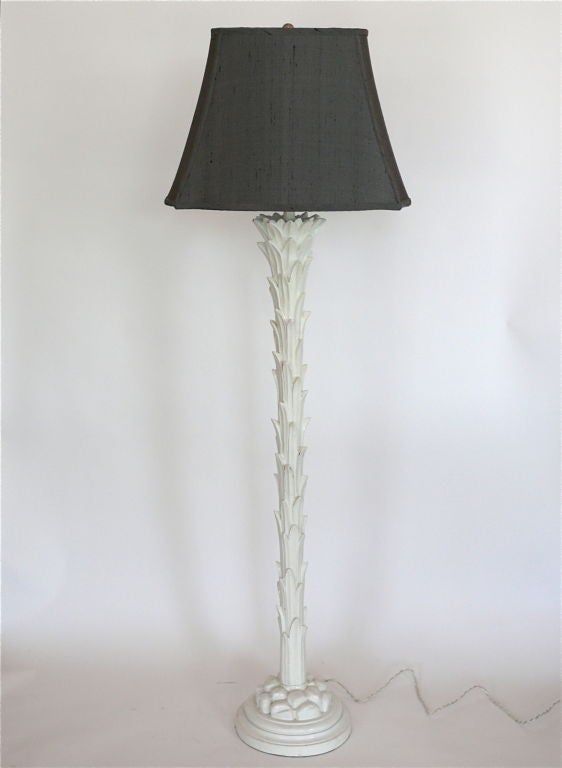 Striking pair of palm torchiere floor lamps in the style of the French designer Serge Roche. Each carved wood and glazed white plaster lamp with overlapping palm leaves flaring at the stem and resting on a rock clustered base.