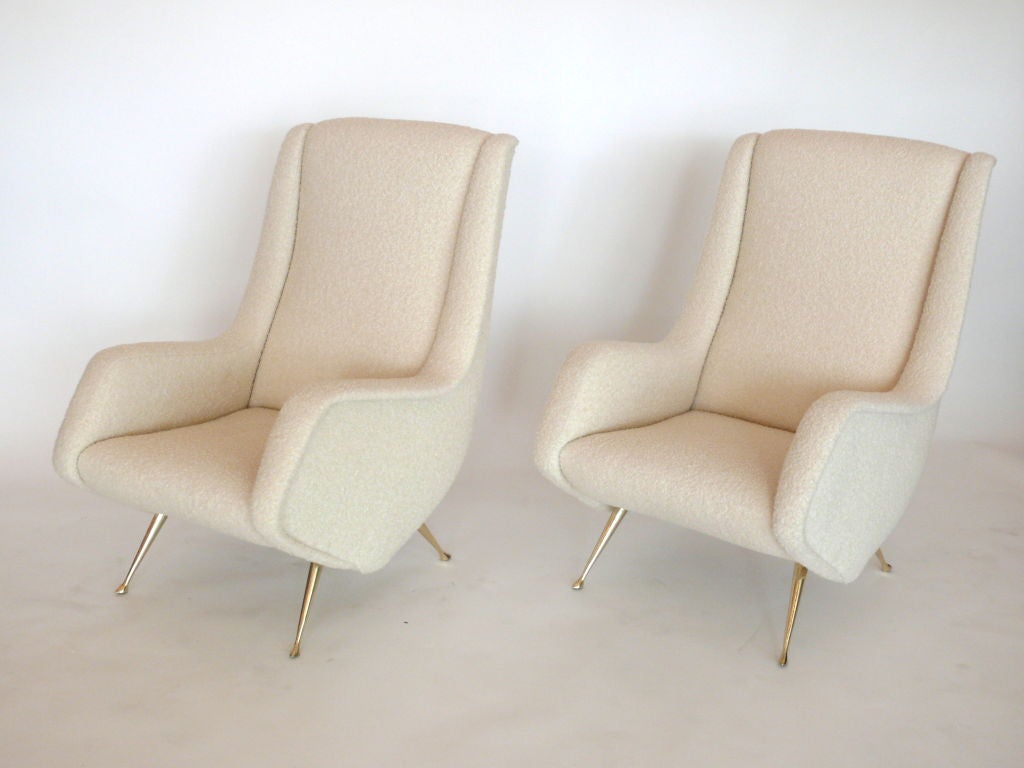 Gorgeous pair of Italian chairs in the style of Marco Zanuso. Newly upholstered in creamy white wool boucle fabric and resting on angled polished brass legs. Fantastic sculptural form.