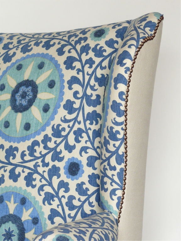 Whimsical upholstered wingback chair with white linen on the back and sides and blue textured pattern on front seat.  Base is newly lacquered in dark grey.  Great addition to any room!