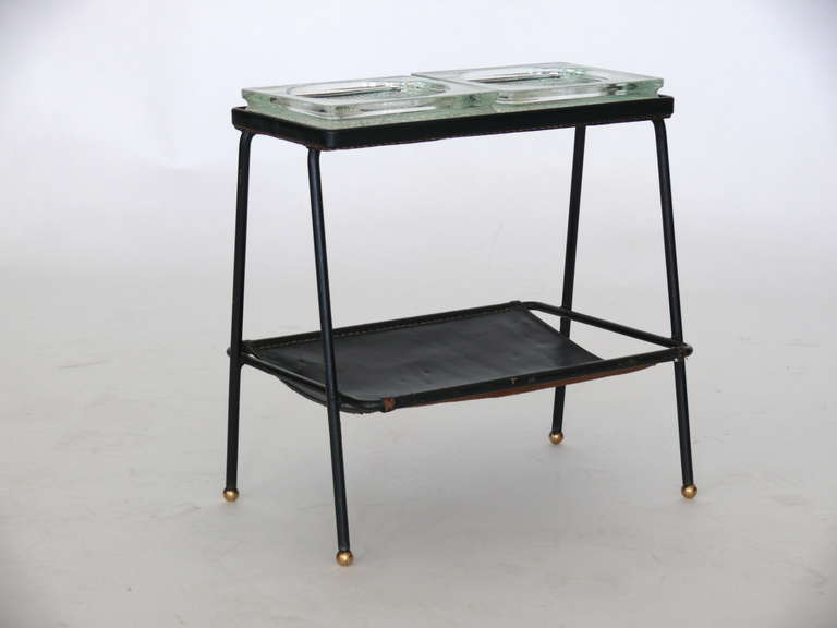 Rare double wide Jacques Adnet catch-all with original black leather and original glass trays. Magazine rack underneath standing on brass ball feet. Clean lines and gorgeous design. Small chip on one glass tray. Excellent vintage condition.